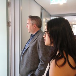 Two people look into a kitchen on tour of the new building