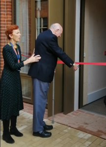 Trevor hughes cuts a ribbon with large