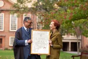 Gopal Subramanium receives a certificate of his Fellowship from Principal Jan Royall while standing on the quadrangle