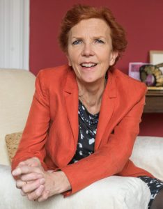 College Principal Jan Royall leans at the sofa in her office.