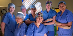 An image of Professor Bhatti in the operating theatre with a group of women surgeons, all in scrubs