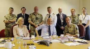 Kata Escott sits at a table with various high-ranking officials from the MOD, including the DCDC Think Tank Director Major General Darrell Amison and the FCO's Angus Lapsley