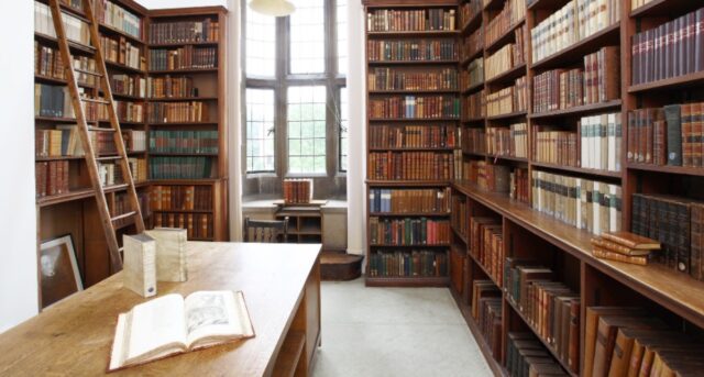 Interior of John Stuart Mill collection in Somerville Library - large number of leather bound books ion shelves