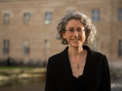 A woman in a dark jacket smiles at the camera
