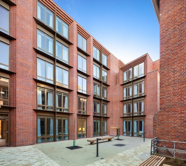 Internal courtyard with bench and large brick building surrounding