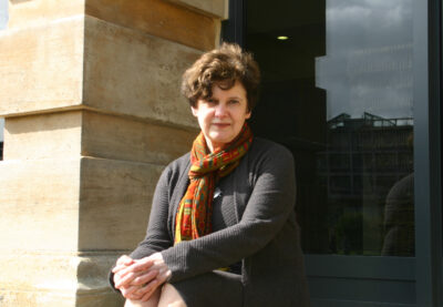 Former Principal Alice Prochaska sitting on steps outside the library