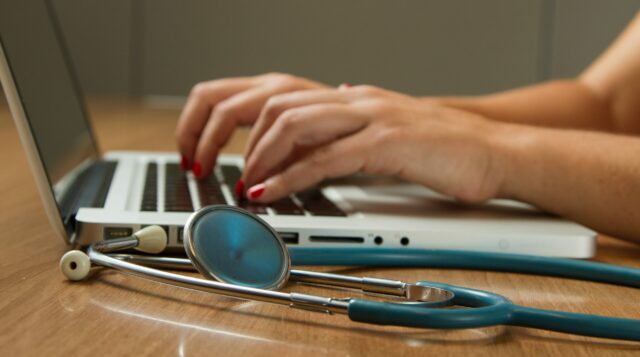 Close-up of hands typing on laptop