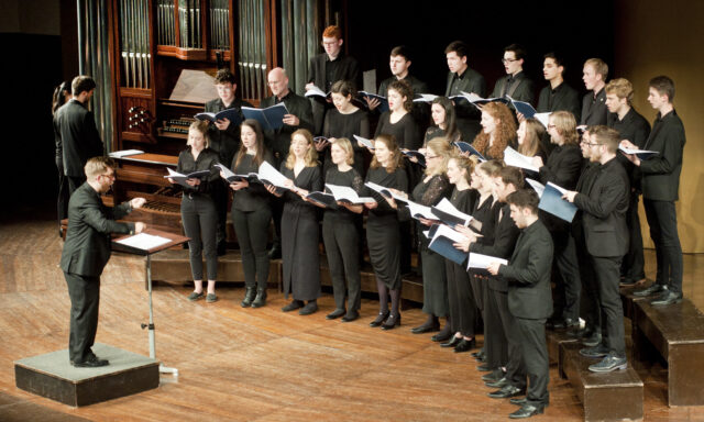 Somerville College Choir standing in a tiered semicricle singing