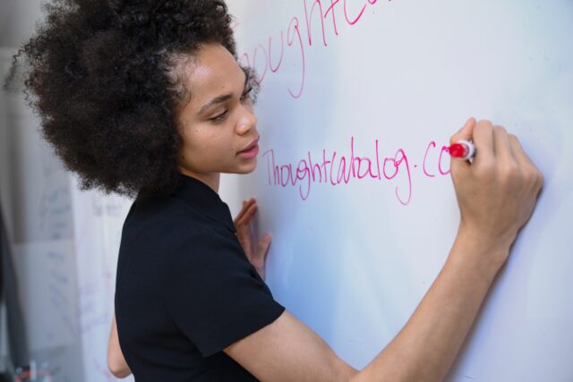 Person writing on whiteboard