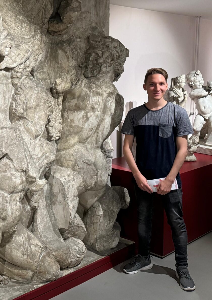 Aivin next to a copy of a relief of Porphyrion on the Pergamon Altar (now in Berlin; this copy in Leiden) Credit: Martijn Oei