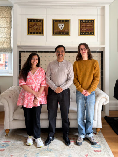 Three people stand next to each other and smile, facing the camera