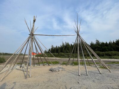 Two connected wooden structures under a blue sky.