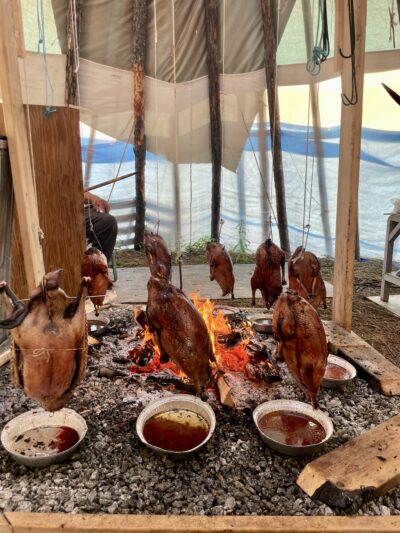 Hunted birds hanging around a fire.