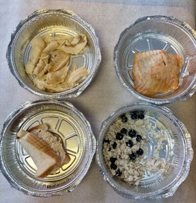 Four tinfoil pots, each with a different kind of fish in it.