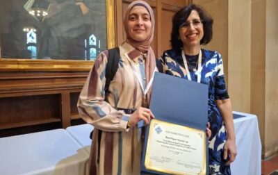 Two smiling women hold up a certificate.